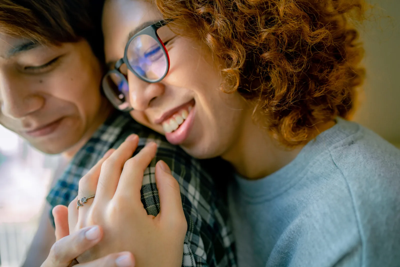 A smiling couple leaning together and holding hands.