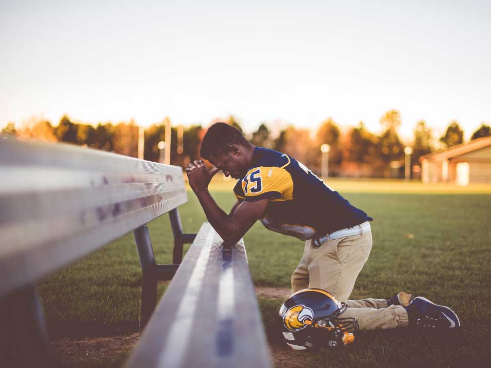 Athlete kneeling on the sidelines